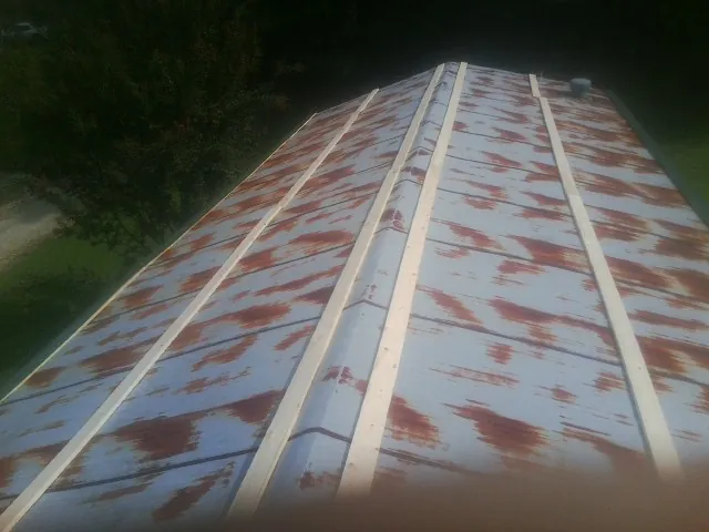 Rusted metal roof panels with new wood purlins before replacement — Storm Damage Roof Repair in Pemberton by Roofing Brothers