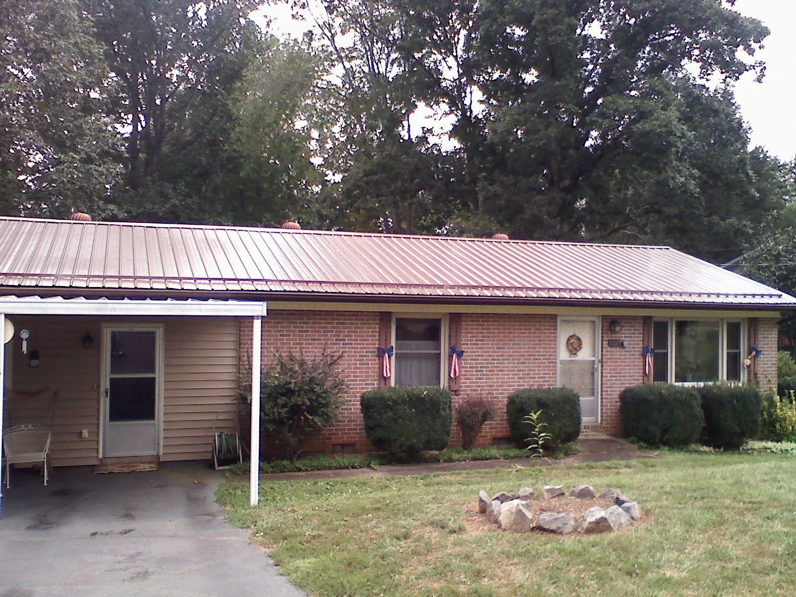 Bronze metal roof and carport on a brick ranch home — Roof Repair work by our crew in Pemberton